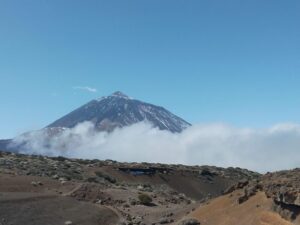 Ein Vulkan, der Teide, ragt aus den Wolken hervor.